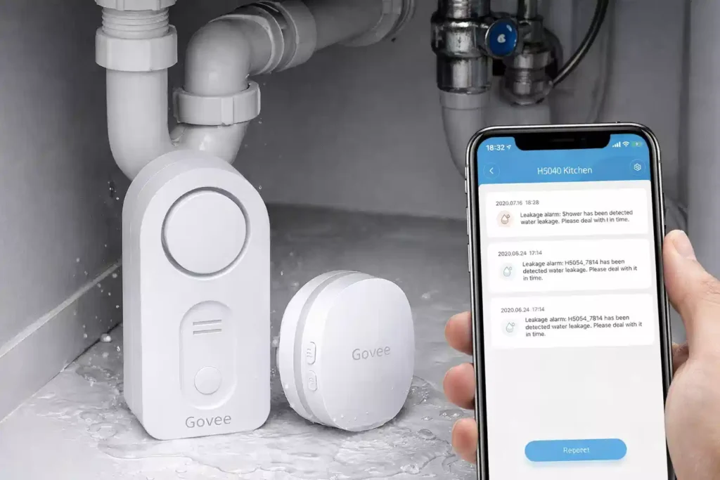 Govee smart water leak detector with gateway and mobile app notification showing water leakage alert under a kitchen sink.
