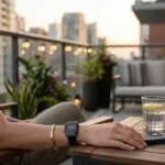 A realistic close-up of a Thermacell E-Series and an Ultrasonic Mosquito Repellent Watch on a modern balcony.