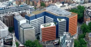 A high-angle aerial view of a modern colorful office complex designed for engineering the soundscape and optimizing urban acoustics in a busy city.