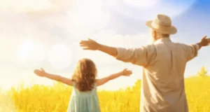 Human-Centric Lighting scene: a young girl and an elderly man in a sunlit field, arms outstretched — symbolizing freedom, nature, vitality, and intergenerational harmony.