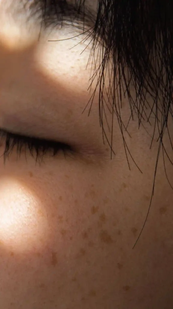 Close-up of facial skin and eyelashes in compact space, showing sunlight effects and UV risks for skincare.